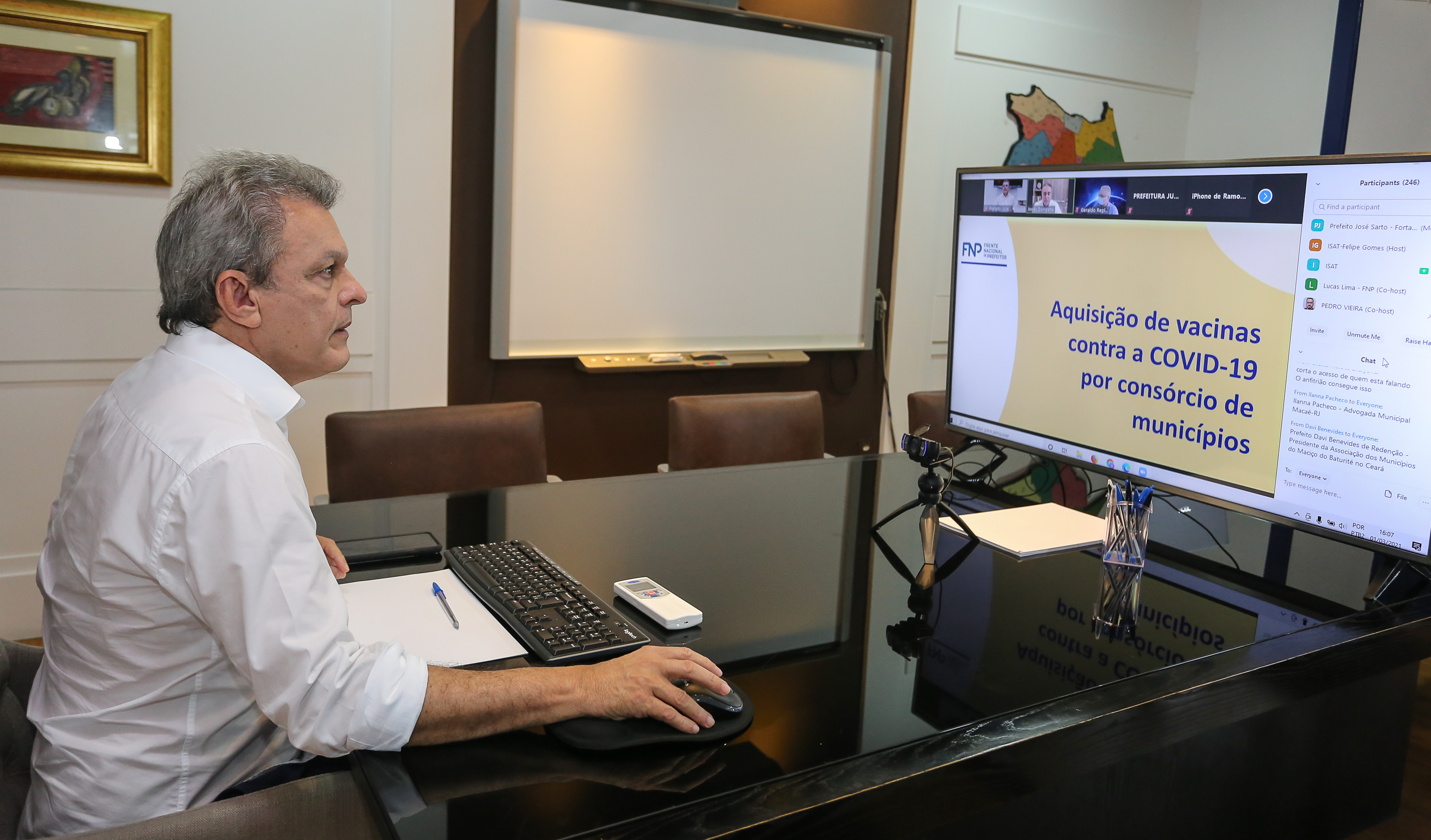 prefeito sarto na frente de uma tela de computador em seu gabinete